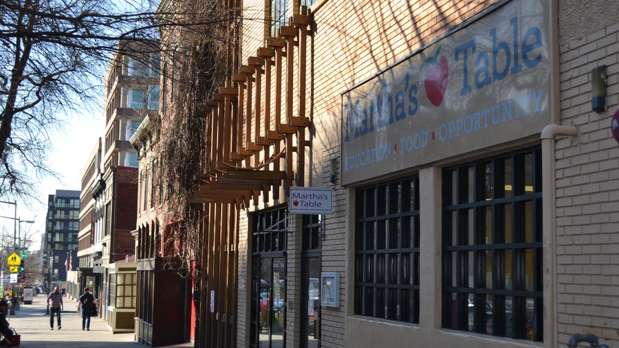 The Martha&rsquo;s Table building at 2114 14th Street NW, Washington, seen from the sidewalk, with EDUCATION, FOOD, OPPORTUNITY painted beneath the sign