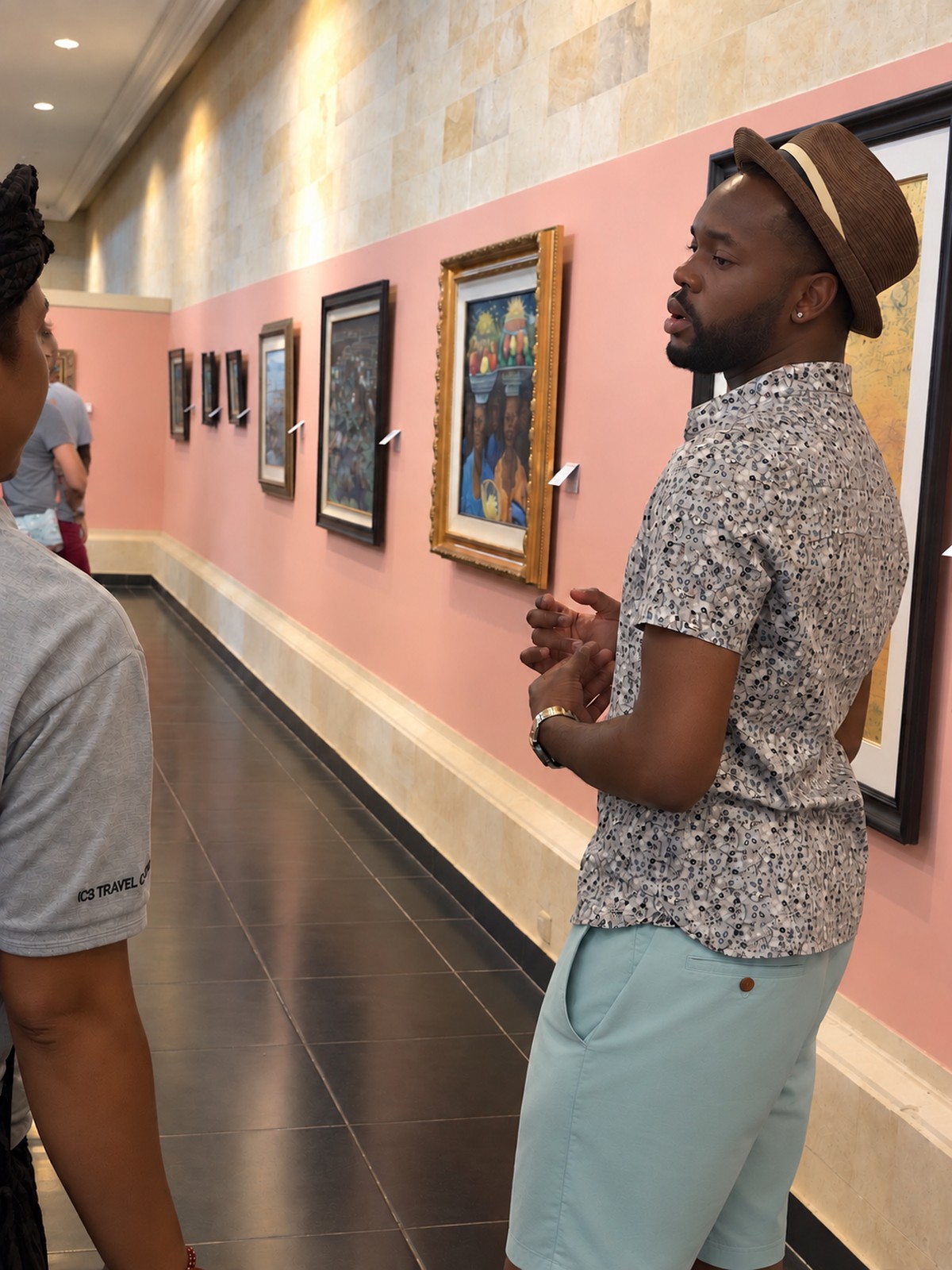 Michael Olaiya in profile, looking at a wall of paintings in a gallery in Bali